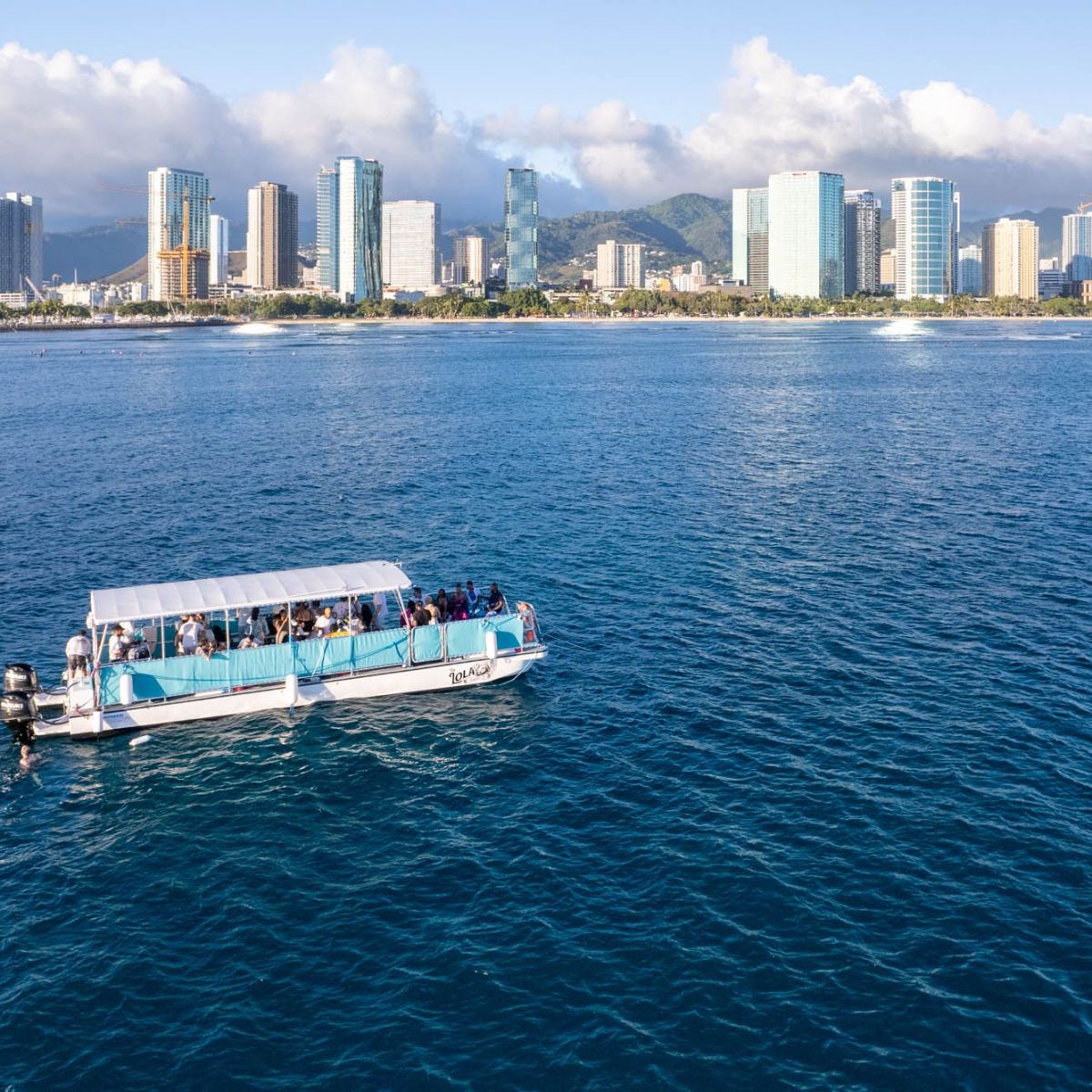 a large ship in a body of water with a city in the background